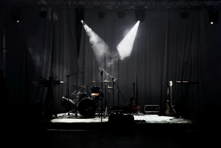 Concert stage with dramatic spotlights and drum kit